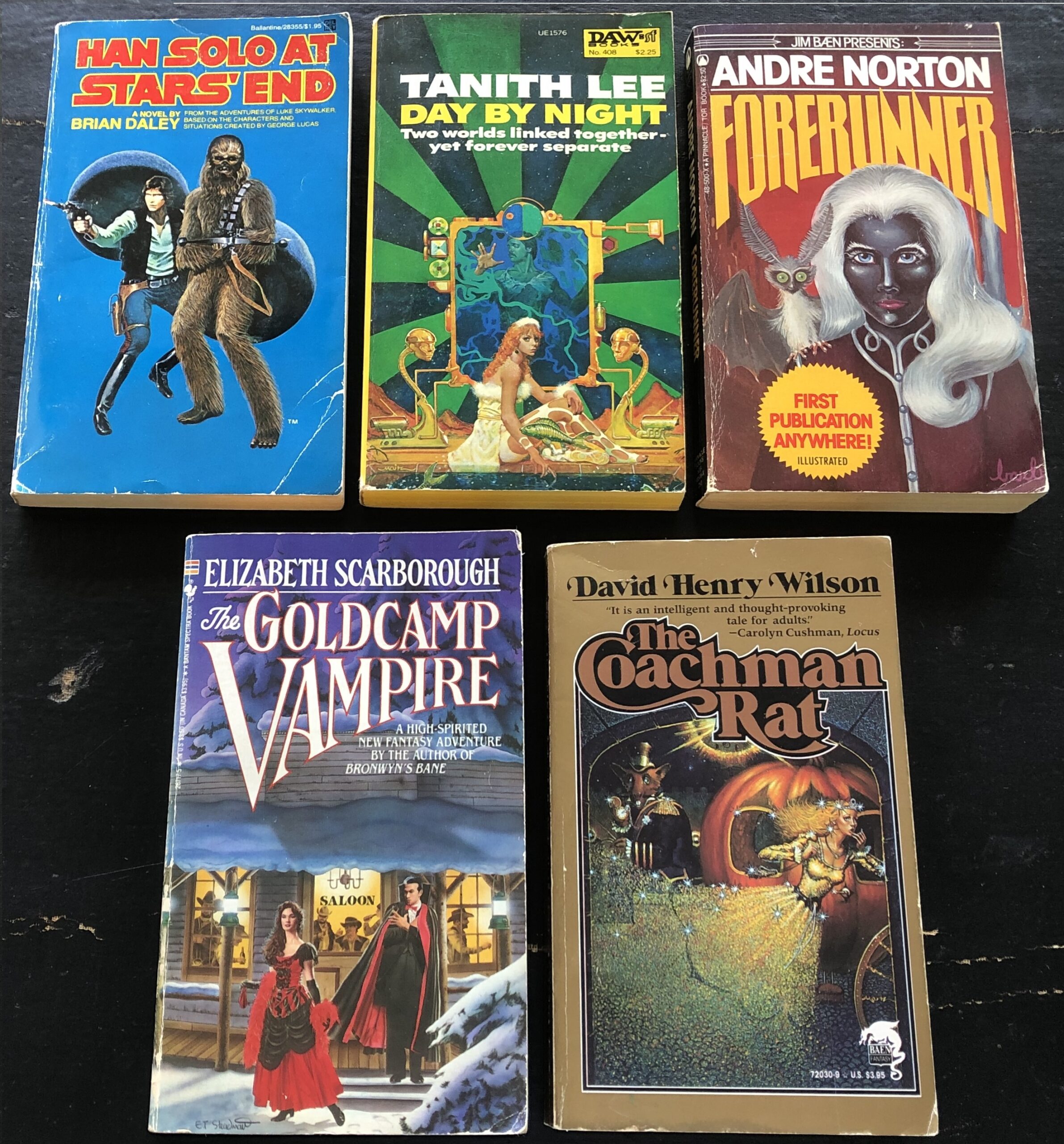 From left to right: Hans Solo at Stars’ End by Brian Daley, 1979, Del Rey, cover art uncredited; Day by Night by Tanith Lee, 1980, DAW, cover art by Don Maitz; Forerunner by Andre Norton, 1981, “Jim Baen Presents” Tor, cover art and interior illustrations by Barbi Johnson; The Goldcamp Vampire by Elizabeth Scarborough, 1987, Bantam Spectra, cover art by E.T. Steadman; and The Coachman Rat by David Henry Wilson, 1990, Baen, cover art uncredited. Photo by Rosemary Jones, from the author’s collection.